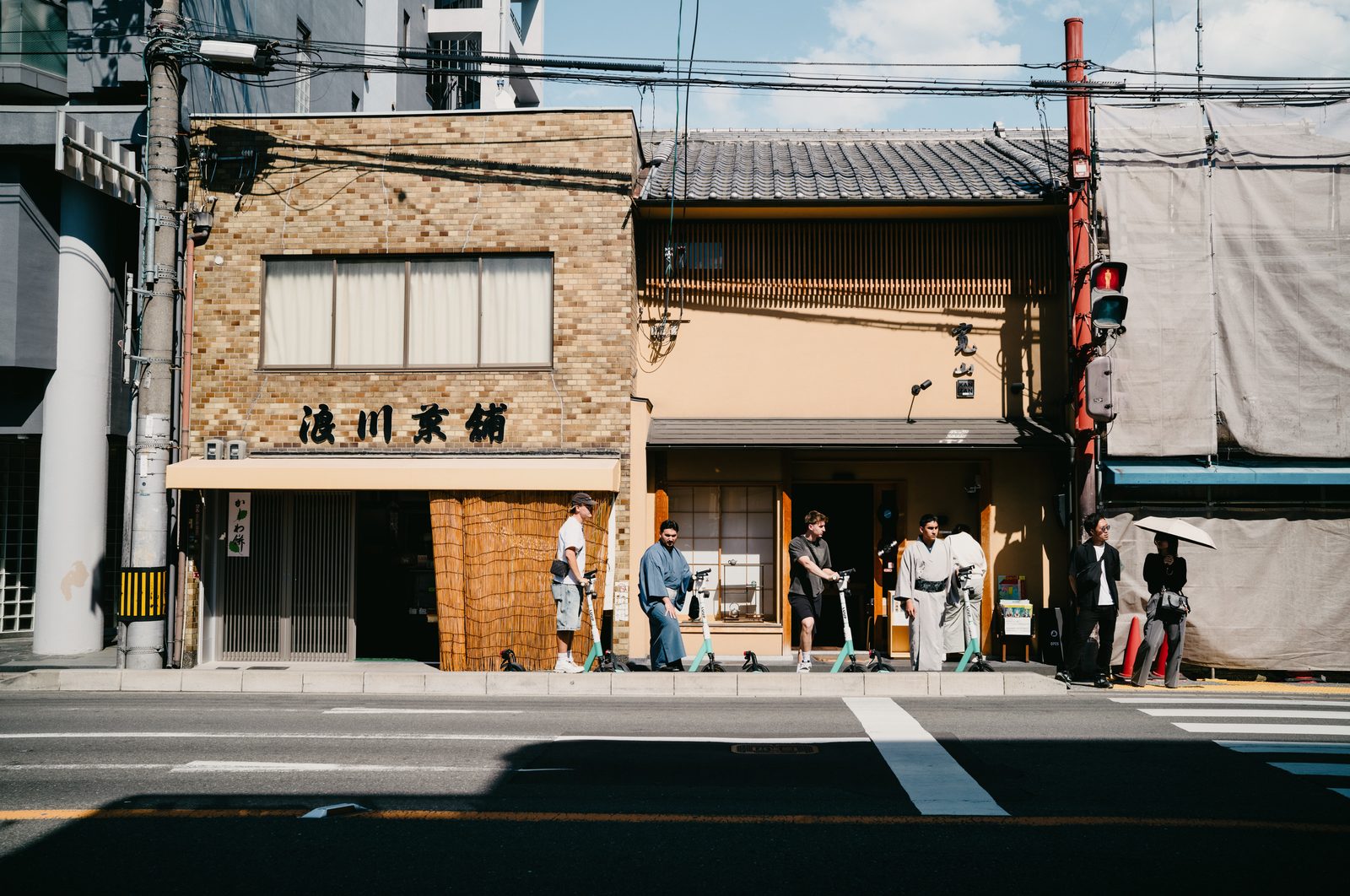 茶舖與木造店面並列在街道對側，行人站在簷下與路口。